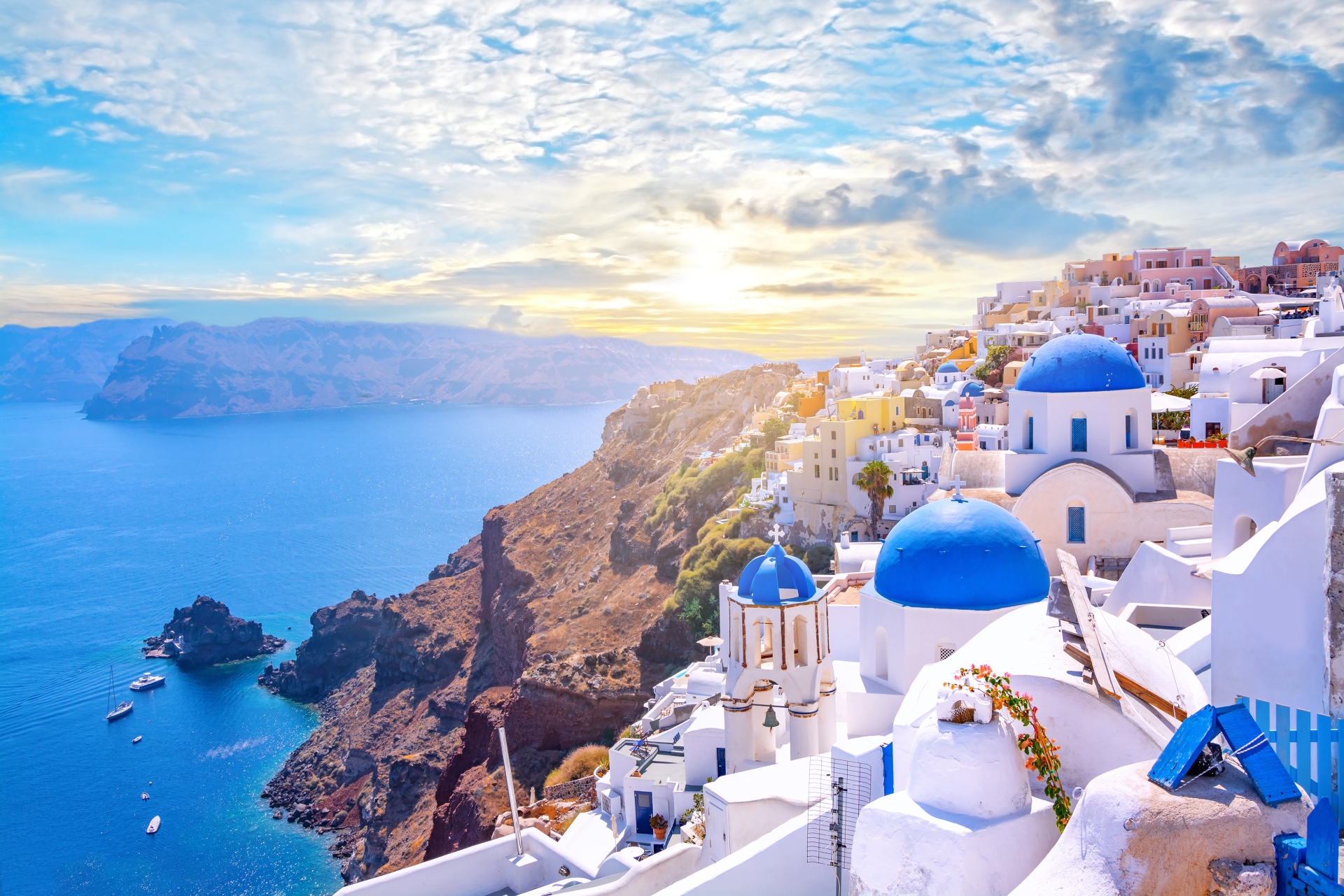 Beautiful Oia town on Santorini island, Greece. Traditional white architecture and greek orthodox churches with blue domes over the Caldera, Aegean sea. Scenic travel background. Griechenland